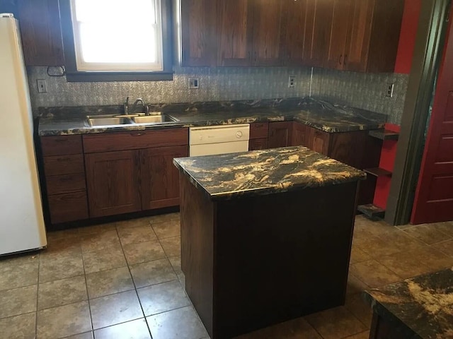 kitchen with tasteful backsplash, white appliances, a sink, a center island, and light tile patterned flooring