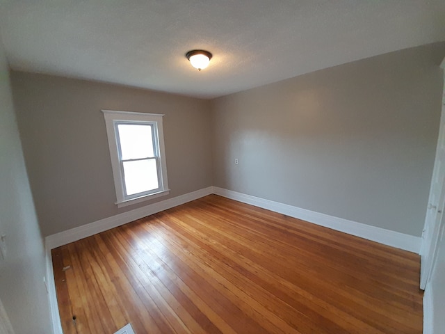 unfurnished room with baseboards and light wood-style floors