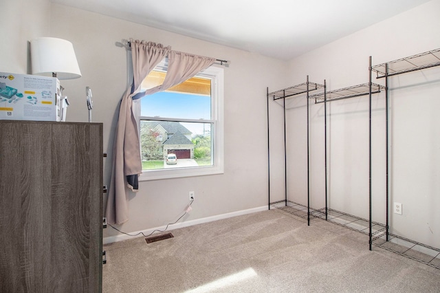 unfurnished bedroom with carpet floors, baseboards, and visible vents