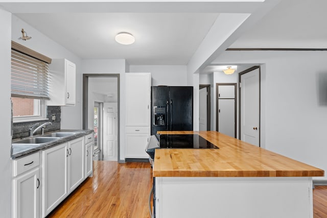 11394 Centralia, Redford, MI 48239 - kitchen featuring white cabinets, a sink, light wood finished floors, butcher block counters, and black fridge with ice dispenser