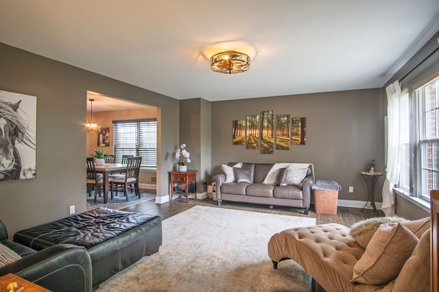 8313 Mill Pointe Ct, Goodrich, MI 48438 - living room with wood finished floors, plenty of natural light, baseboards, and a chandelier