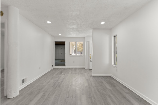 spare room featuring visible vents, wood finished floors, a textured ceiling, and recessed lighting