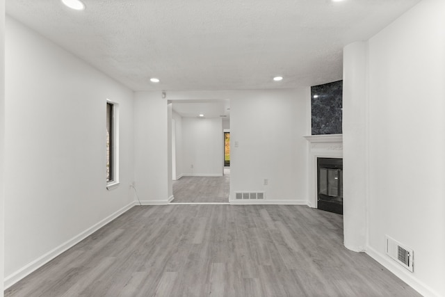 unfurnished living room featuring wood finished floors, visible vents, and recessed lighting