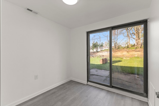 interior space with baseboards, visible vents, and wood finished floors