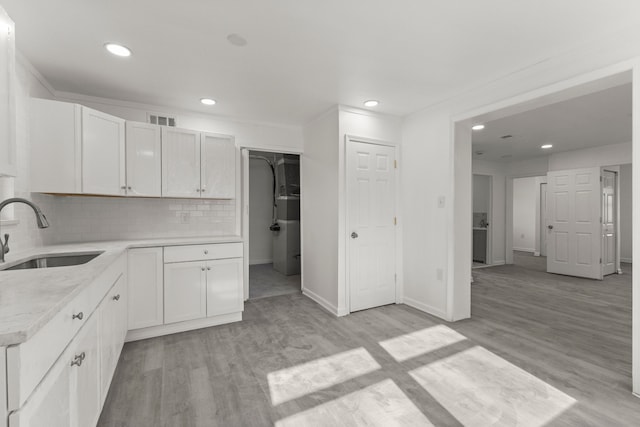 kitchen with visible vents, recessed lighting, light wood finished floors, and a sink