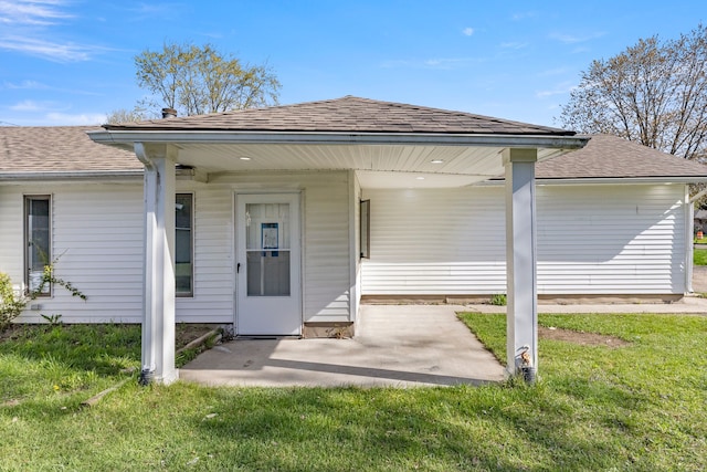 back of house with a patio, a shingled roof, and a yard