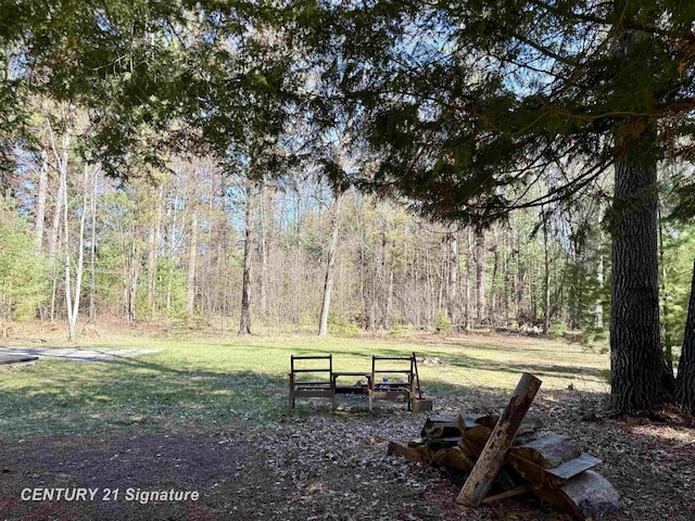 view of property's community with a yard and a wooded view