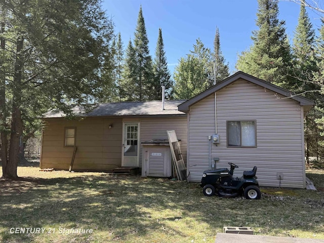 rear view of property featuring a yard