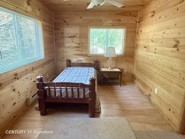 bedroom with wood walls, a ceiling fan, light wood finished floors, and wood ceiling