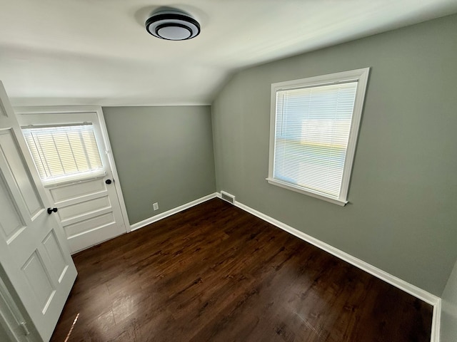 additional living space featuring baseboards, dark wood finished floors, and vaulted ceiling