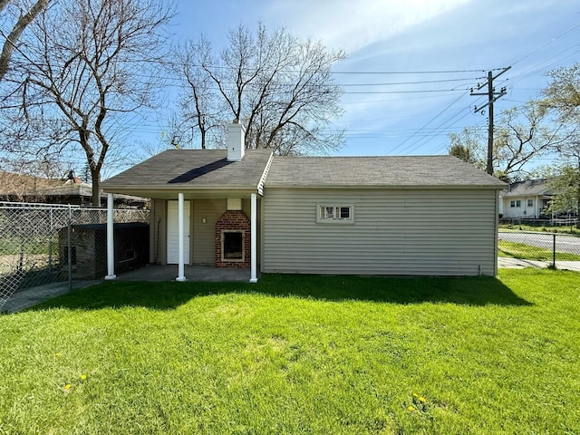 rear view of property with fence, a chimney, and a yard