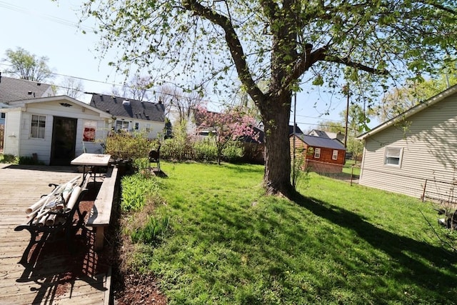 view of yard with an outdoor structure, a wooden deck, and fence