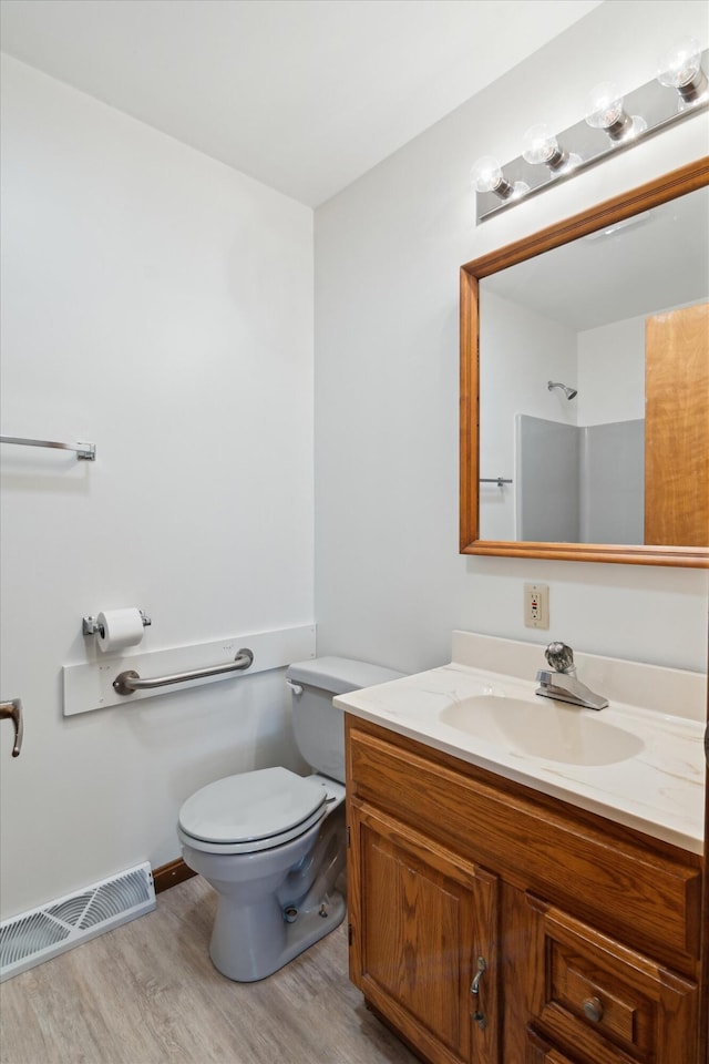 7996 Cain Rd, Jackson, MI 49201 - bathroom featuring visible vents, baseboards, toilet, wood finished floors, and vanity