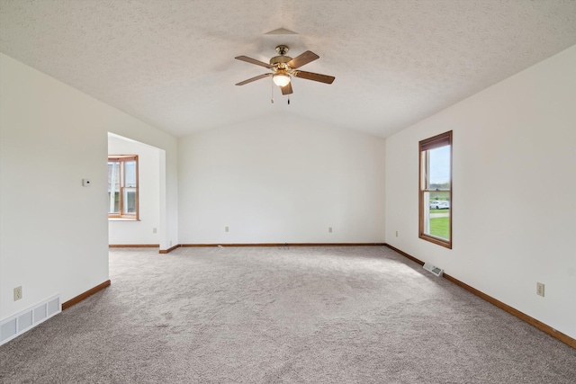 7996 Cain Rd, Jackson, MI 49201 - carpeted empty room featuring visible vents, a ceiling fan, vaulted ceiling, and baseboards