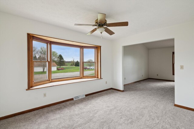 7996 Cain Rd, Jackson, MI 49201 - carpeted empty room featuring visible vents, a ceiling fan, and baseboards
