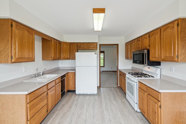7996 Cain Rd, Jackson, MI 49201 - kitchen with white appliances, light wood-type flooring, brown cabinetry, and a sink