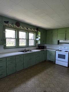 600 Benson Rd, Benton Harbor, MI 49022 - kitchen featuring white electric range oven, green cabinetry, a sink, light countertops, and under cabinet range hood