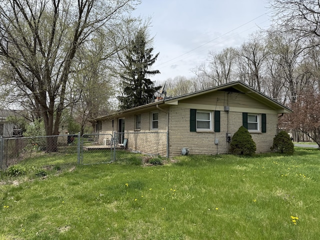 5346 E H Ave, Kalamazoo, MI 49048 - view of side of home featuring fence, a gate, a lawn, and brick siding