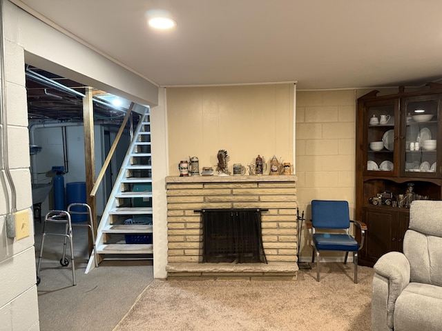5346 E H Ave, Kalamazoo, MI 49048 - carpeted living room featuring stairway, a fireplace with raised hearth, and concrete block wall