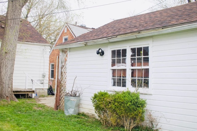 view of side of home featuring roof with shingles