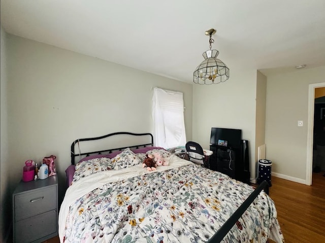 bedroom with baseboards and wood finished floors