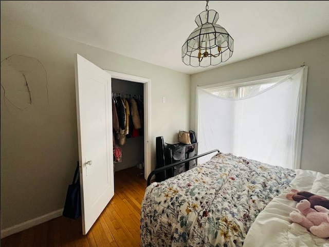 bedroom with baseboards, a closet, and hardwood / wood-style floors
