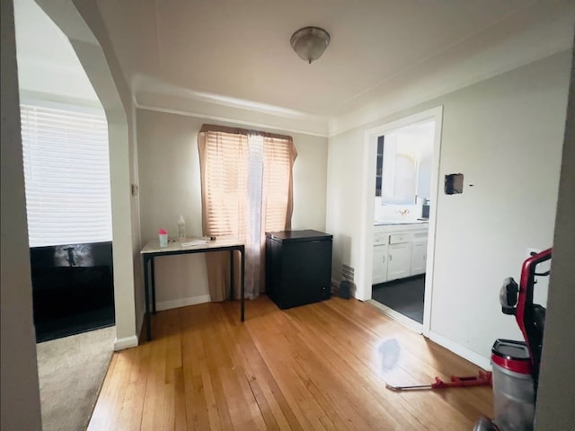 interior space featuring baseboards and light wood finished floors