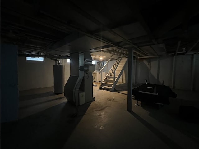 below grade area featuring stairway, heating unit, and water heater