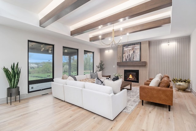 living room featuring visible vents, light wood-style flooring, beam ceiling, and a large fireplace
