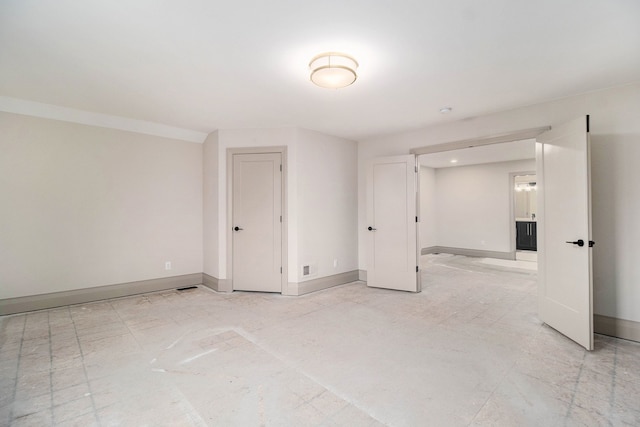 empty room featuring baseboards and visible vents