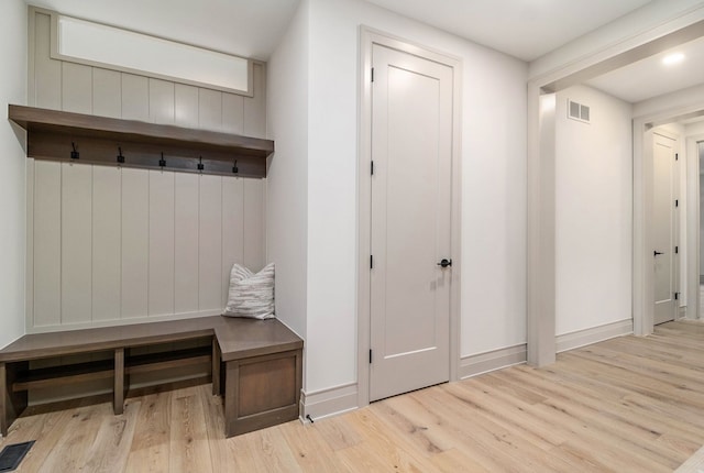 mudroom featuring baseboards, visible vents, and wood finished floors