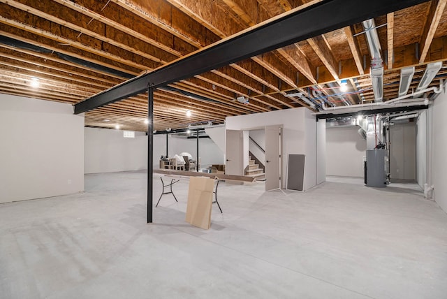 below grade area featuring stairs and gas water heater