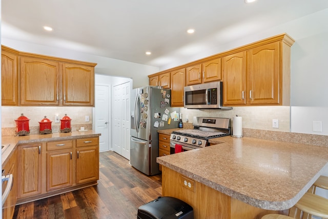 12031 E Schonborn Pl N Unit 3, Clio, MI 48420 - kitchen featuring decorative backsplash, appliances with stainless steel finishes, a breakfast bar area, and a peninsula
