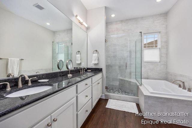 full bathroom featuring a garden tub, a sink, and a shower stall