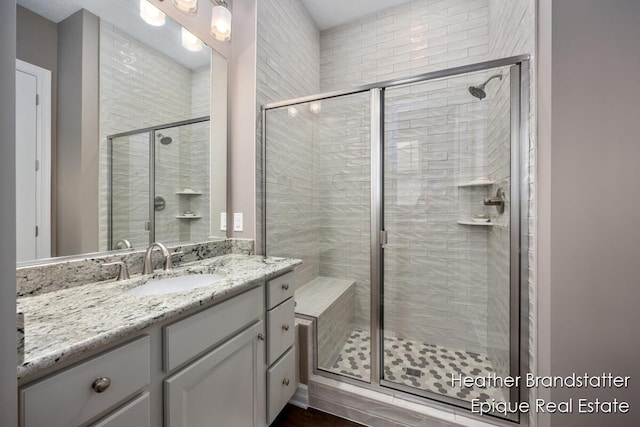 full bath featuring vanity and a shower stall