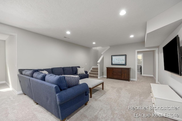 living area with recessed lighting, stairs, light colored carpet, and a textured ceiling