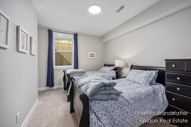 bedroom with visible vents, light carpet, and baseboards
