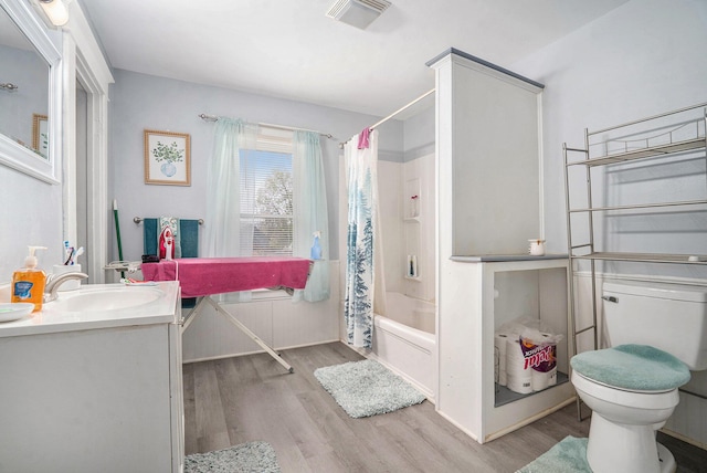 bathroom featuring vanity, toilet, shower / tub combo, visible vents, and wood finished floors
