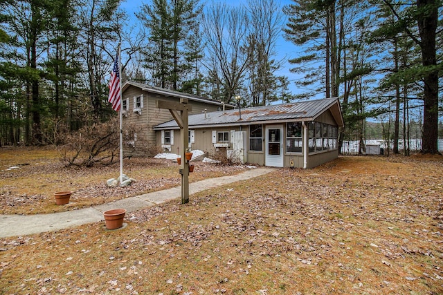 view of front of home with metal roof and a sunroom