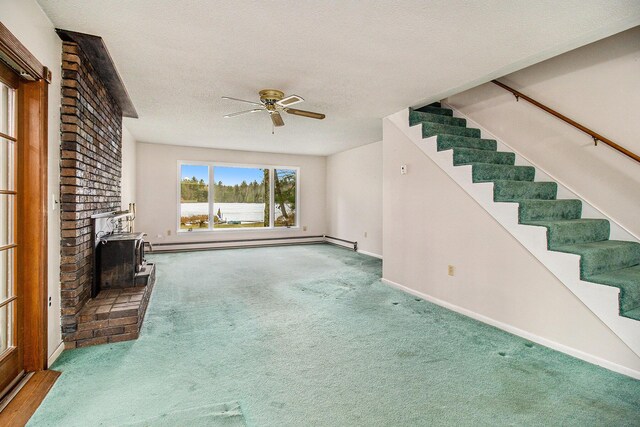unfurnished living room featuring a baseboard radiator, carpet, a wood stove, a ceiling fan, and a textured ceiling