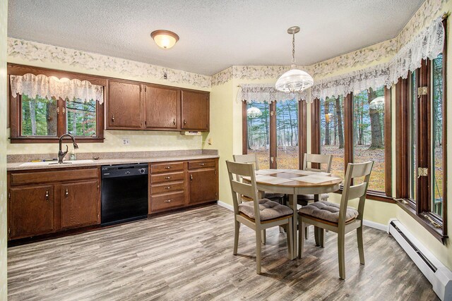 kitchen featuring a baseboard radiator, dishwasher, light wood-style flooring, and a sink