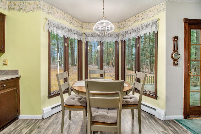 dining area featuring a notable chandelier, baseboard heating, and baseboards