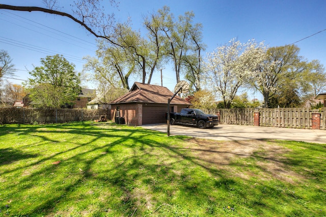 view of yard featuring fence, driveway, and a garage