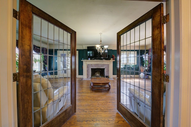 interior space featuring crown molding, wood finished floors, and a notable chandelier