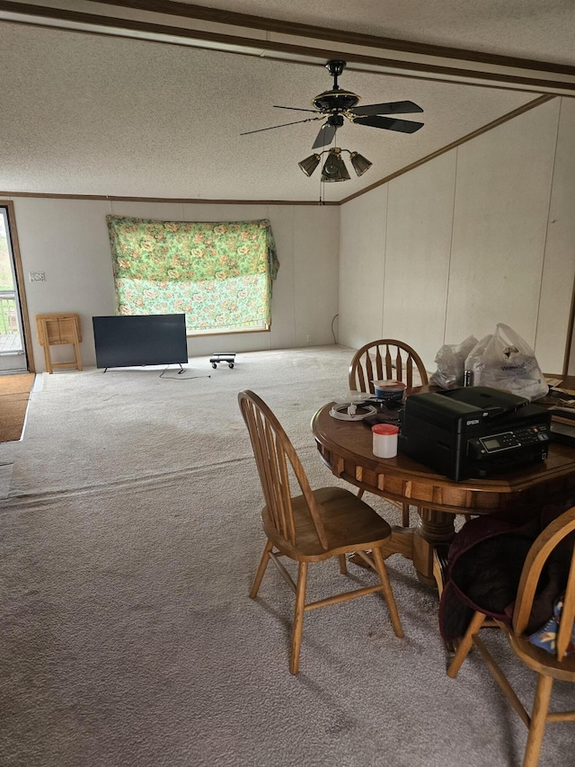 carpeted dining area with a healthy amount of sunlight, ceiling fan, and crown molding