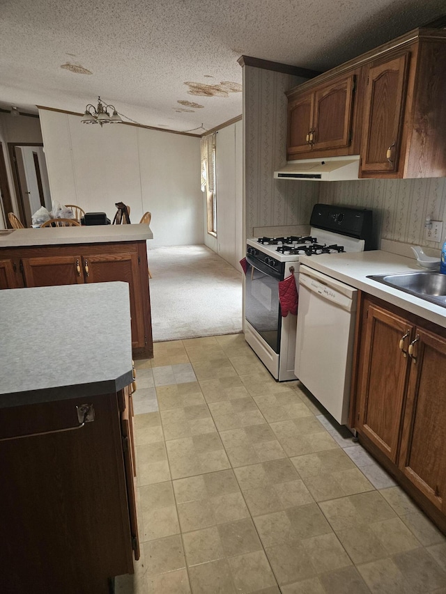 kitchen with range with gas stovetop, a textured ceiling, dishwasher, and under cabinet range hood