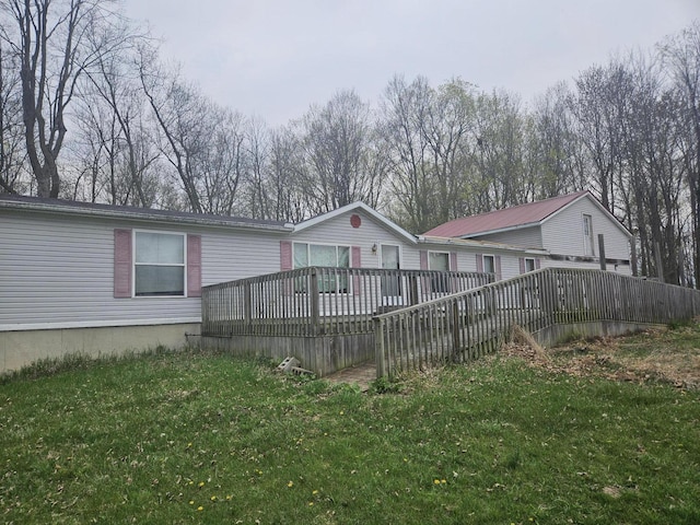 back of property featuring a lawn and a deck