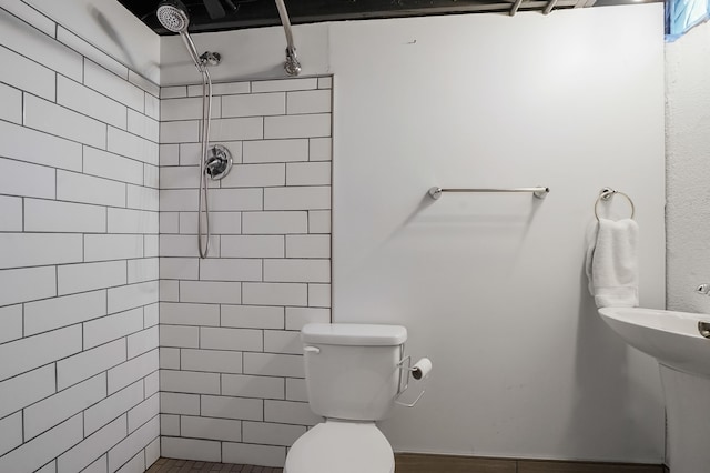 full bath featuring toilet and a tile shower