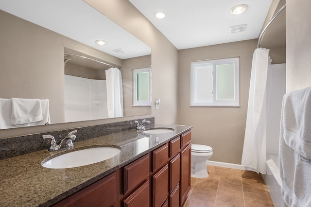 bathroom featuring baseboards, toilet, double vanity, and a sink