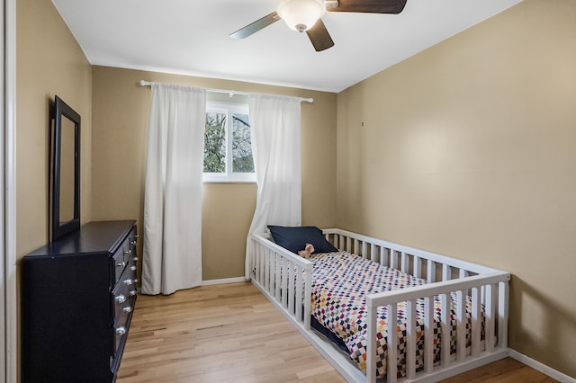 bedroom with light wood-style floors, ceiling fan, and baseboards